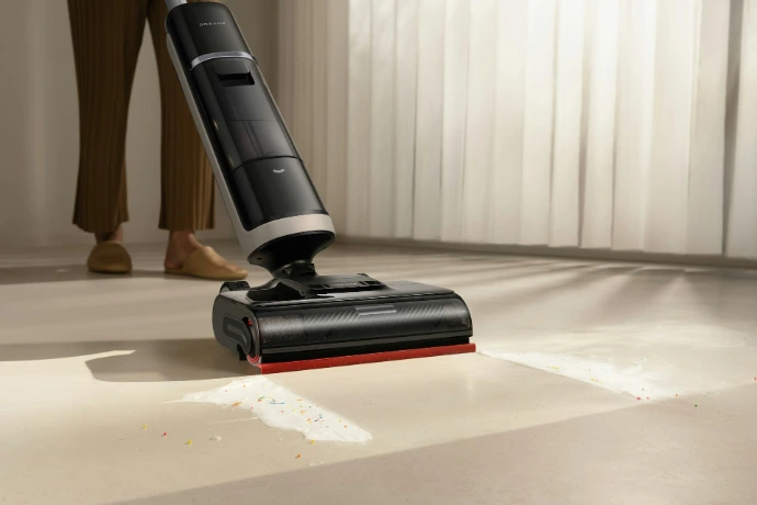 A person using a cordless vacuum cleaner on a floor.